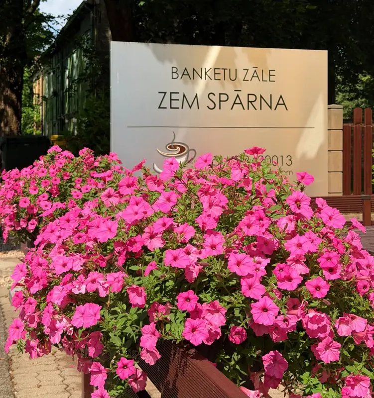 Banketu zāles «Zem spārna» izkārtne ar puķēm